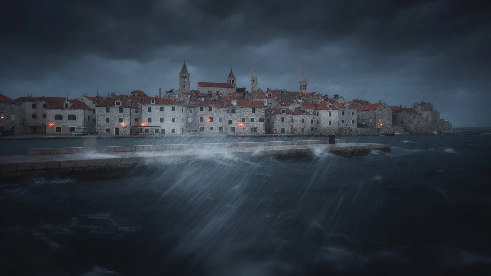Stari grad Rab s četiri zvonika za jake bure, valovi prelijevaju rivu